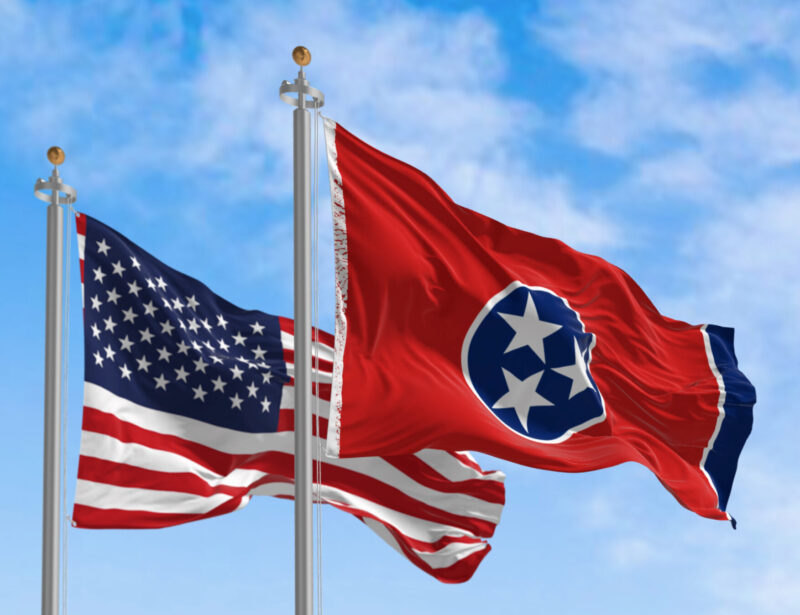 waving flags of USA and Tennessee state next to each other