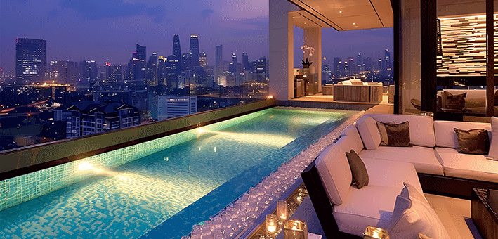 A rooftop pool overlooking a city at night